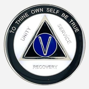 A distinctive AA sobriety medallion (approximately 34mm) featuring a bold black outer enamel ring and a crisp white inner ring. The center prominently displays a blue AA circle and triangle symbol, surrounded by the words 'Unity,' 'Service,' and 'Recovery.' The outer edge includes 'To Thine Own Self Be True' and the sobriety anniversary year (in Roman numerals, 1-40 years). The token has a smooth, glossy finish that highlights its contrasting colors.