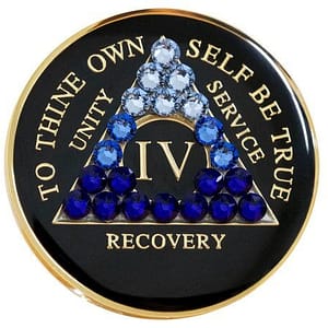 A black and gold coin with blue stones on it.