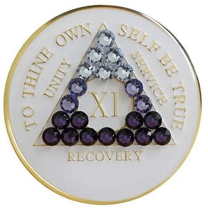 A white and gold colored medal with purple stones.