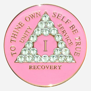 This Crystal AA Medallion features soft pink Swarovski crystals and delicate diamond accents, symbolizing self-love and acceptance on the recovery journey.