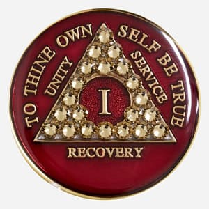 A red crystal AA medallion with gold accents, featuring the AA symbol and sobriety year options.