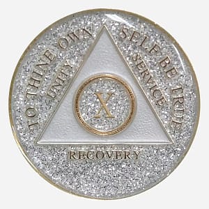 This image shows the front of the Triplate AA Token Glitter Silver, featuring the classic AA triangle within a circle, symbolizing unity and recovery, set against a backdrop of shimmering silver glitter. Above, the inscription "To Thine Own Self Be True" serves as a powerful reminder on your journey.