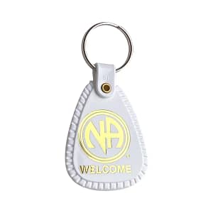 A white key chain with the word " welcome " written on it.
