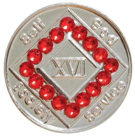 A silver coin with red beads around it.
