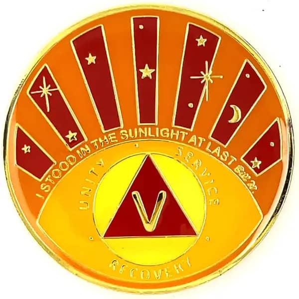 A yellow and red coin with the image of a sun, moon, stars.