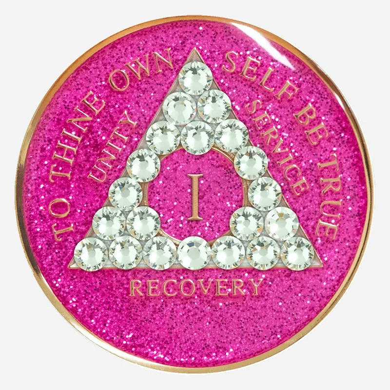 Reflect Grace and Strength with the Crystal AA Medallion Glitter Pink/Diamond The Crystal AA Medallion Glitter Pink/Diamond is a vibrant emblem of resilience and grace, crafted for those committed to the path of sobriety. With a sparkling pink background and diamond-clear Swarovski crystal accents, this medallion serves as a beautiful reminder of each accomplishment. Hand-painted by individuals in recovery, it honors the strength it takes to achieve every milestone, from 1 to 50 years. Features: Material: Made with genuine Swarovski crystals and a radiant pink glitter finish, this Glitter Pink Diamond Crystal AA Medallion symbolizes grace, perseverance, and hope. Each medallion is coated in a scratch-resistant resin dome, maintaining its brilliance through the journey of recovery. Front Design: The AA triangle is surrounded by diamond-clear crystals set against a glittering pink background. The phrase “To Thine Own Self Be True” shines in bold relief, representing the authenticity and courage in sobriety. Roman numerals within the triangle commemorate each year, adding a unique and personal tribute to each milestone. Back Design: A single diamond-clear Swarovski crystal graces the center of the engraved Serenity Prayer on the reverse, providing daily encouragement and serenity. Dimensions: This Crystal AA Chip Glitter Pink/Diamond measures 34mm (1.34 inches) in diameter, designed to be both beautiful and portable, allowing it to serve as a steady reminder of each victory in recovery. Durability: The high-quality resin dome protects the sparkling pink finish and crystal accents from scratches and chips, ensuring this medallion remains as strong and radiant as the individual it represents. Benefits: Symbolism: The glittering pink background paired with diamond-clear crystals symbolizes grace, resilience, and inner strength. This medallion represents the balance between softness and courage, qualities that shine throughout the journey of sobriety. Personalization: Roman numerals marking 1 to 50 years allow for a deeply personal connection to each year in recovery, creating a unique reminder of each milestone achieved and challenge overcome. Gifting: Arriving in an elegant velour pouch, this medallion makes a thoughtful and supportive gift for anyone marking their path in sobriety. Its design offers encouragement and symbolizes the strength and beauty found in each step forward. Order Your Crystal AA Medallion Glitter Pink/Diamond Today Celebrate each milestone with the Crystal AA Medallion Glitter Pink/Diamond. Place your order today to receive fast, free shipping, ensuring that your medallion arrives in time to honor your achievements or support someone on their journey in sobriety. Complete the Gift with: Key Chain Holders Make your medallion a daily companion with one of our durable Key Chain Holders, designed to protect and display your token with elegance and ease. Sober Greeting Cards Pair your medallion with a heartfelt message by selecting from our Sober Greeting Cards, perfect for sharing words of encouragement and marking each milestone. Book Covers with Chip Holders Display your medallion alongside your recovery literature with one of our stylish Book Covers with Chip Holders, crafted to protect both your medallion and books as you journey forward.