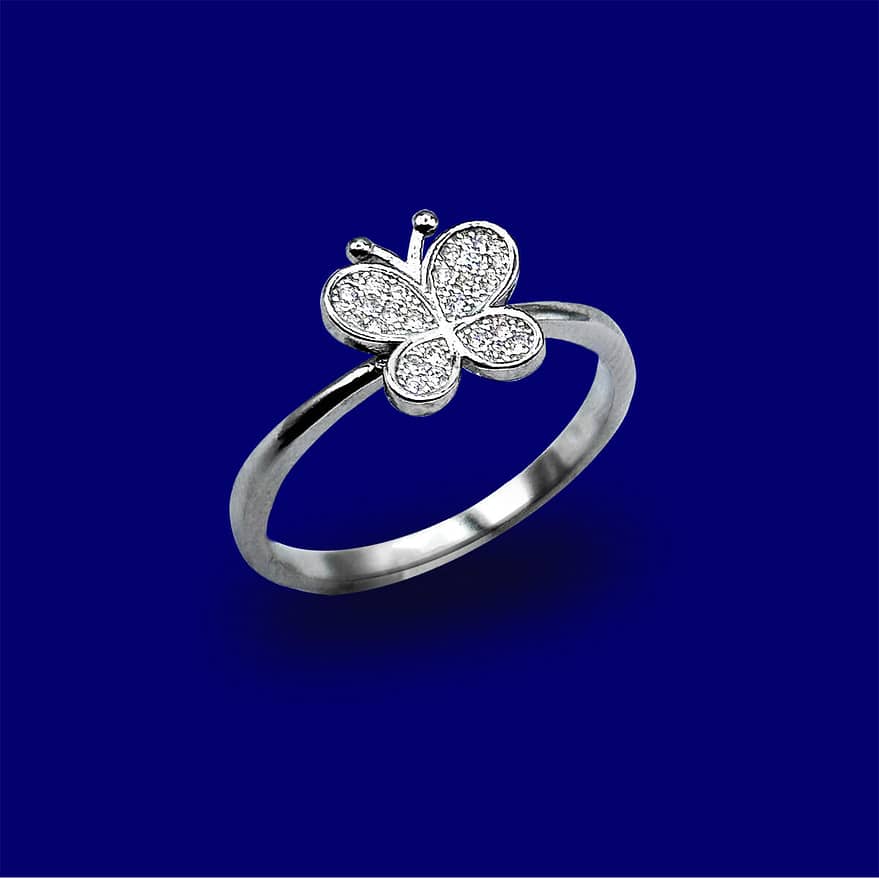 A silver ring with a butterfly on it's side.