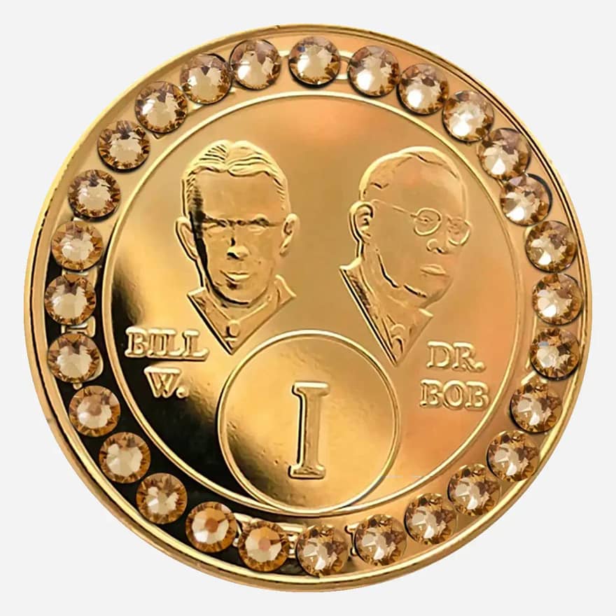 Gold AA medallion with light topaz accents, featuring stylized busts of Bill W. and Dr. Bob, commemorating sobriety.