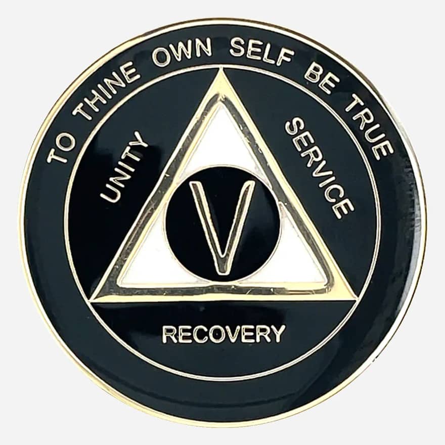 A black and pearl AA triplate token with gold accents, with the words "To Thine Own Self Be True" and "Unity Service Recovery" on the front of coin.