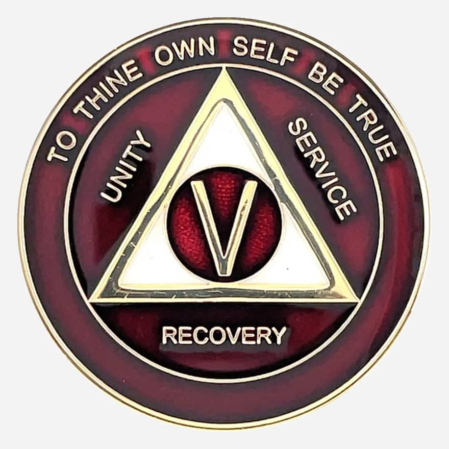 Alcoholics Anonymous medallion (34mm) with a rich burgundy enamel border and a shimmering pearlized center. Features a gold-plated AA circle and triangle symbol, encircled by 'Unity,' 'Service,' 'Recovery' in gold lettering. The outer edge reads 'To Thine Own Self Be True' and the sobriety year (1-50), all in gold. The coin has a glossy, epoxy-coated finish that enhances its deep colors and provides durability.