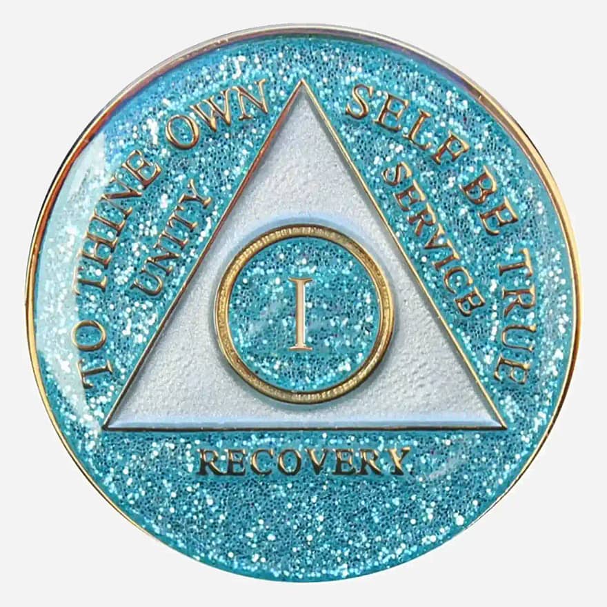 Close-up of the Triplate AA Token Glitter Aqua, showcasing the intricate detailing of the AA symbol and "To Thine Own Self Be True" motto against the sparkling aqua background.