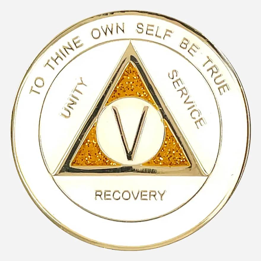 The front of AA triplate token in white and gold with gold glitter accents, having the words "To Thine Own Self Be True" and "Unity Service and Recovery" written on it.